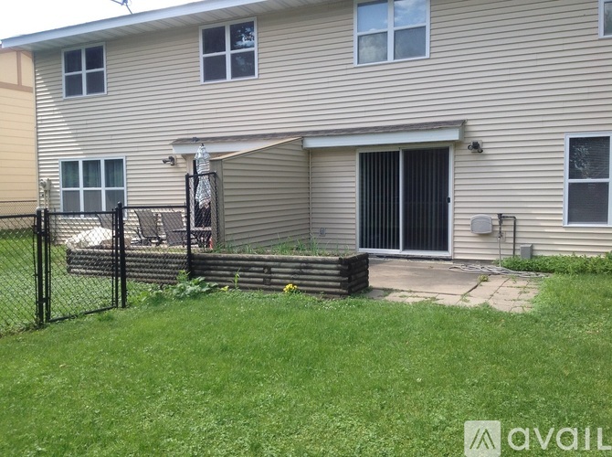 A house with a grey siding and a black fence.