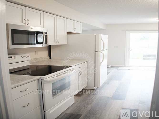 A kitchen with white appliances and cabinets.