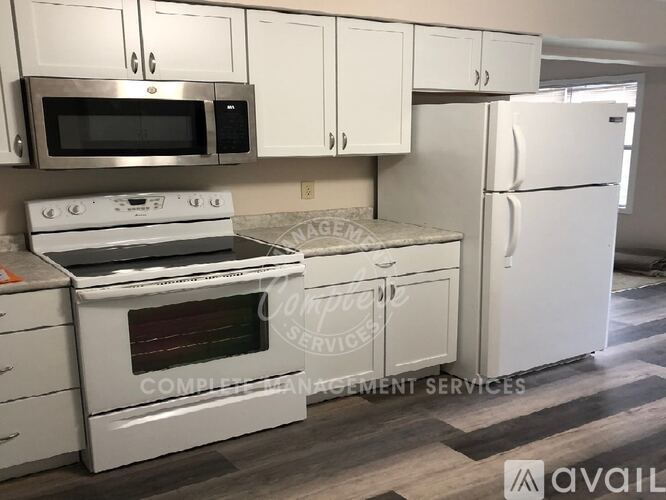 A kitchen with white appliances and cabinets.