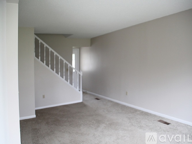 A spacious empty room with a staircase.