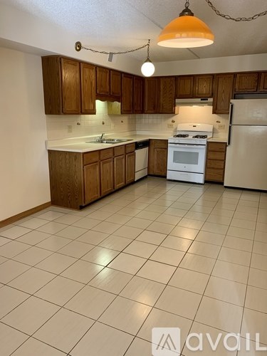 A kitchen with white appliances and wooden cabinets.