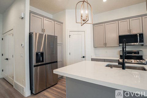 A kitchen with a stainless steel refrigerator and a white countertop.