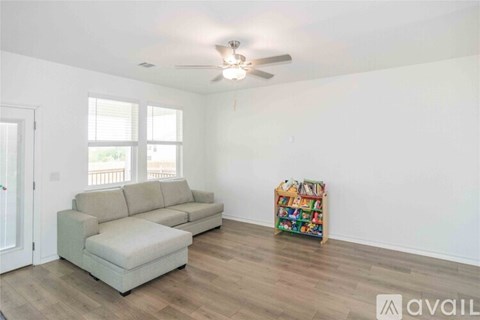 A living room with a grey sofa and a wooden floor.