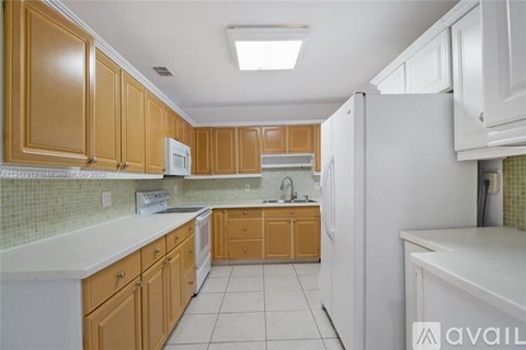 A kitchen with wooden cabinets and a white refrigerator.
