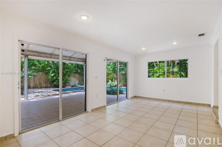 A spacious room with sliding glass doors leading to a backyard.