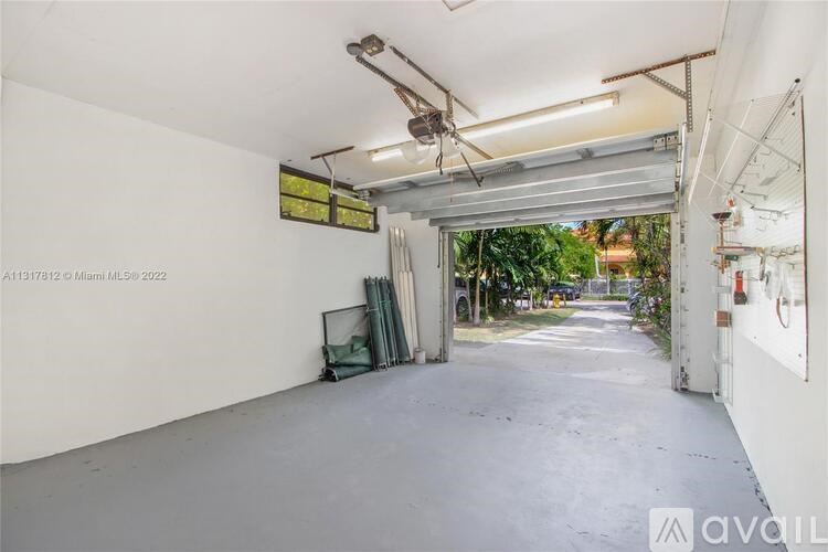 A large, empty garage with a door open to a street.