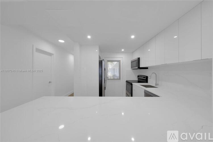 A modern kitchen with white cabinets and a large island.