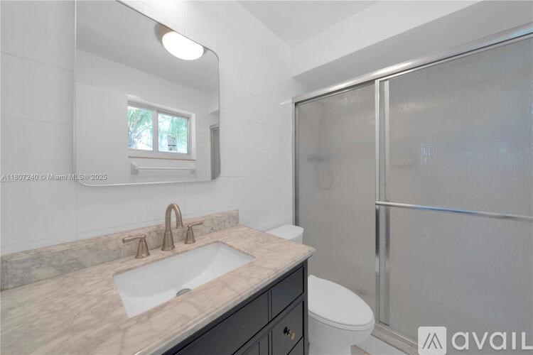 A bathroom with a sink, toilet, and shower.