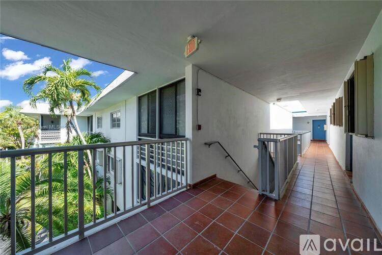 A balcony with a metal railing and a tiled floor.