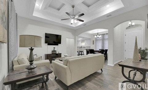 A living room with a white couch and a wooden coffee table.