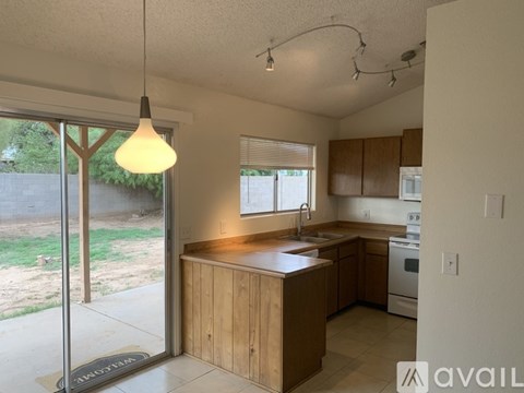 A kitchen with wooden cabinets and a pendant light hanging above the island.