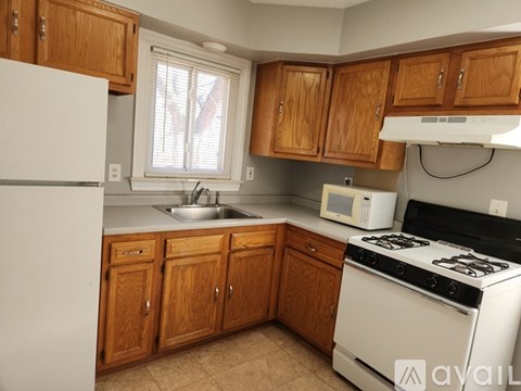 A kitchen with wooden cabinets and a white refrigerator.