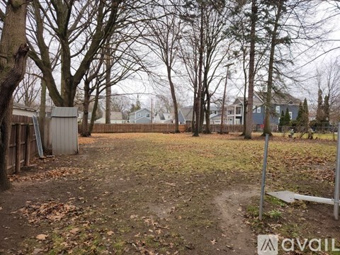 A backyard with a dirt path and trees.