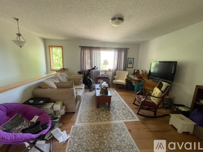 A living room with a purple chair and a television.