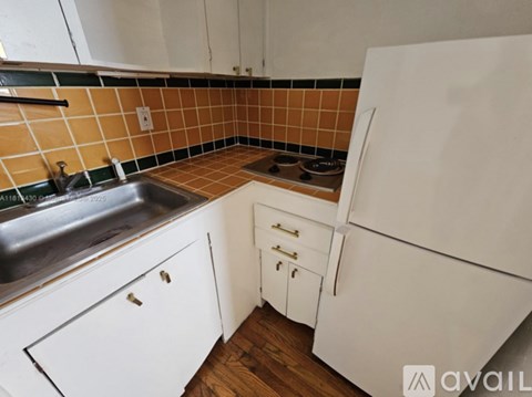 A kitchen with white cabinets and a white fridge.