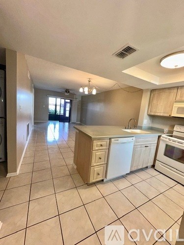 A kitchen with white appliances and cabinets.