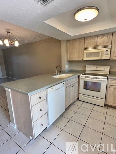 A kitchen with a white dishwasher and white oven.