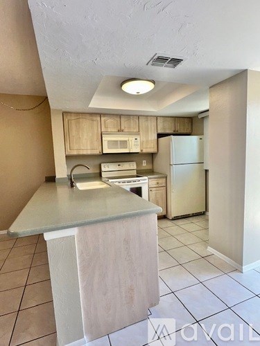 A kitchen with a white fridge and microwave.