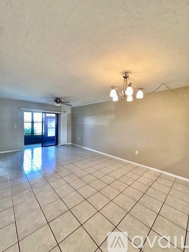 A spacious room with a tiled floor and a ceiling fan.