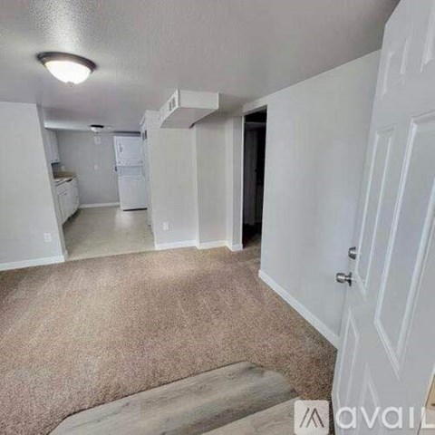A kitchen area with white appliances and a carpeted floor.
