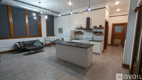 A kitchen with a black countertop and a grey floor.