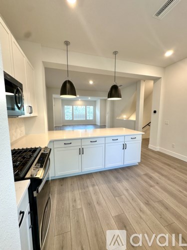 A kitchen with white cabinets and a black stove top oven.