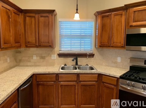 A kitchen with wooden cabinets and a granite countertop.