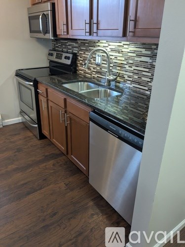 A kitchen with wooden cabinets and a stainless steel sink.