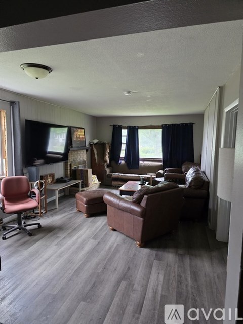 A living room with a brown couch and a red chair.