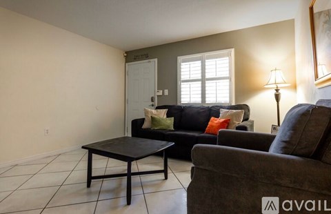 A living room with a black couch and a coffee table.