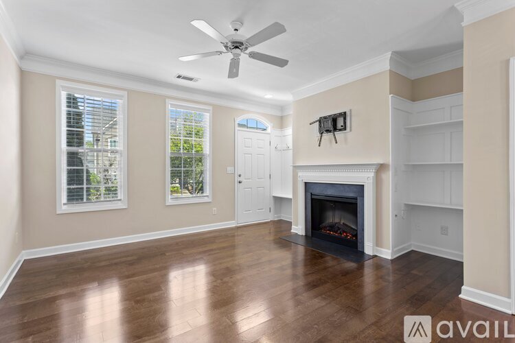 A spacious living room with a fireplace and a ceiling fan.