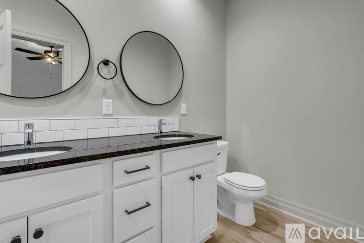 A bathroom with a toilet, sink, and mirror.