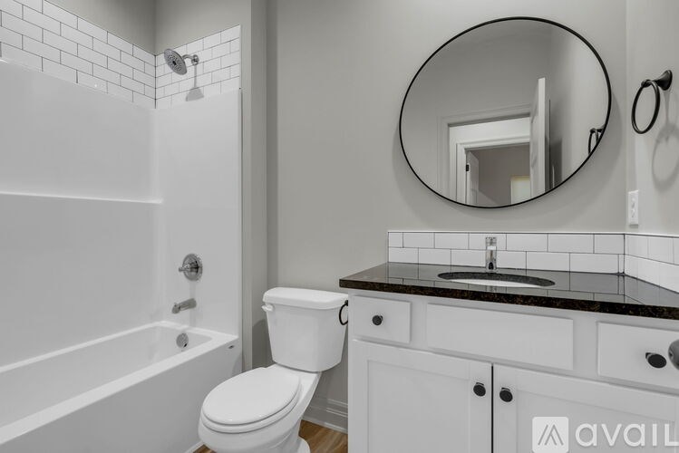 A bathroom with a toilet, sink, and bathtub.