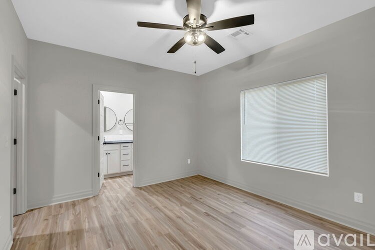 A room with a ceiling fan and a window with blinds.