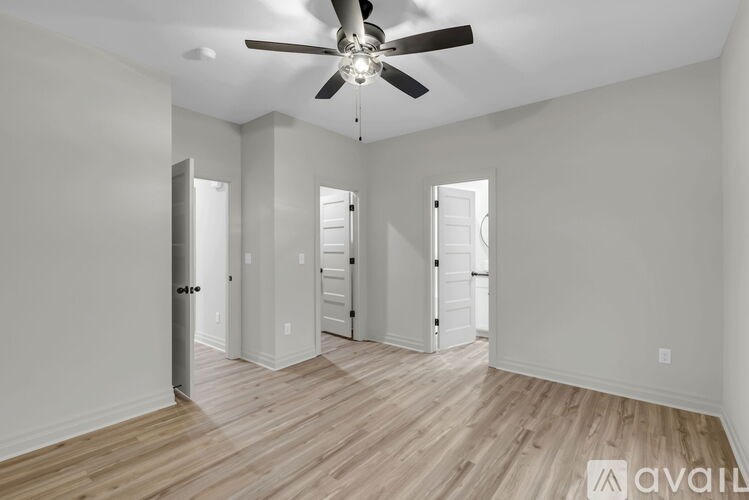 A room with a ceiling fan and wooden flooring.