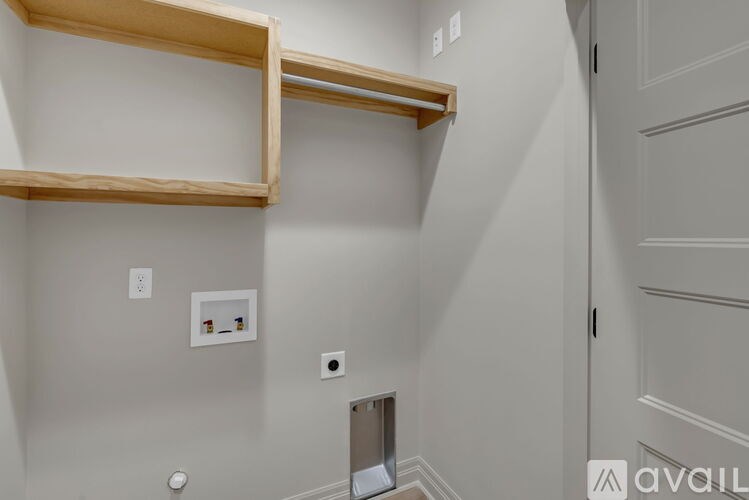 A white wall with a shelf and a door.