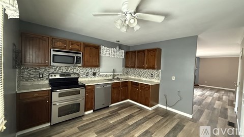 A kitchen with wooden cabinets and a black and white tile backsplash.