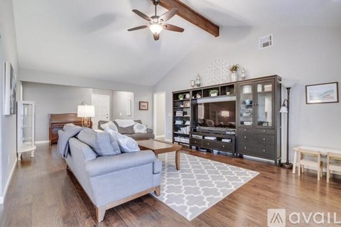 A living room with a grey couch and a wooden floor.