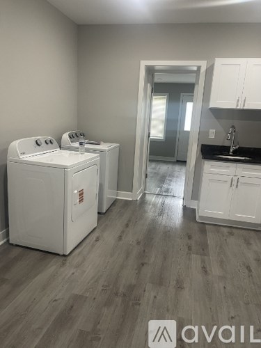 A kitchen with a white dishwasher and cabinets.