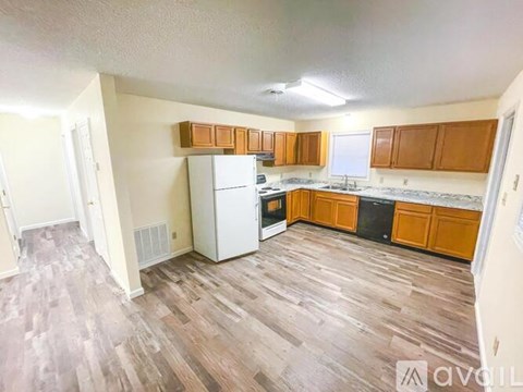 A kitchen with wooden cabinets and a white refrigerator.