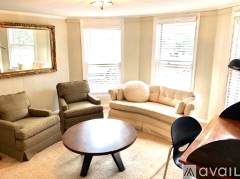 A living room with a brown table and a white couch.