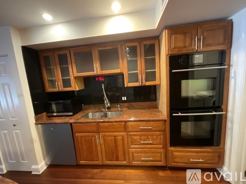 A kitchen with wooden cabinets and black appliances.