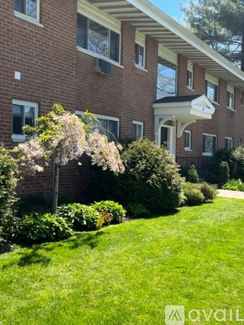 A brick building with a green lawn in front.