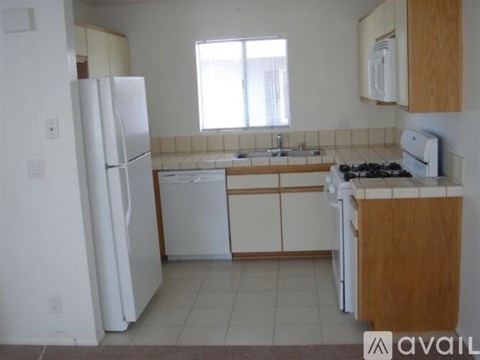 A kitchen with white appliances and wooden cabinets.