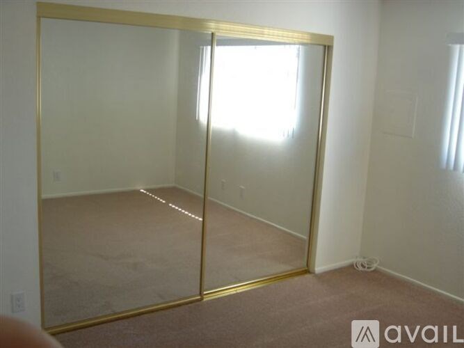 A room with a large mirror and a carpeted floor.