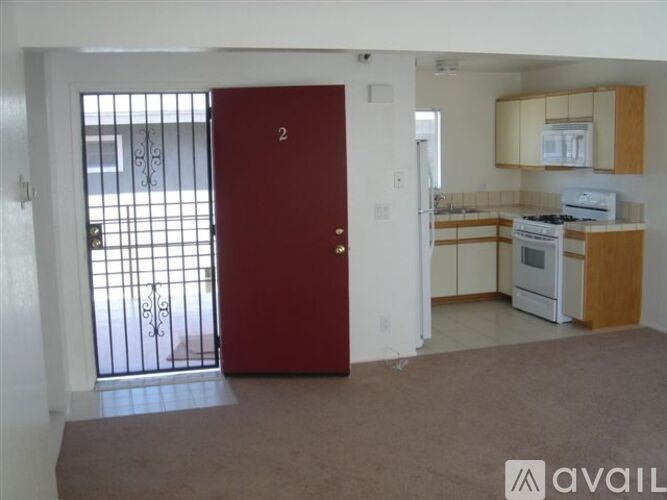 A red door is in the middle of a white wall.