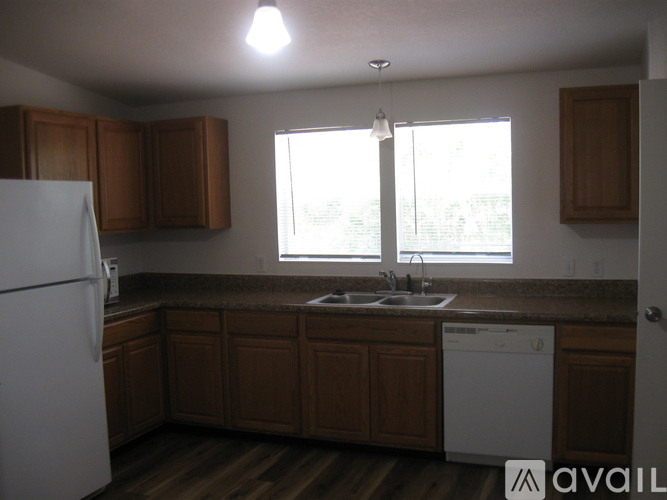 A kitchen with wooden cabinets and a white dishwasher.