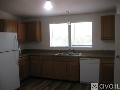 A kitchen with wooden cabinets and a white dishwasher.