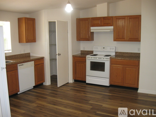 A kitchen with white appliances and wooden cabinets.