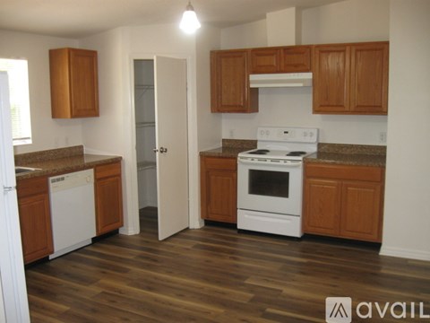 A kitchen with white appliances and wooden cabinets.